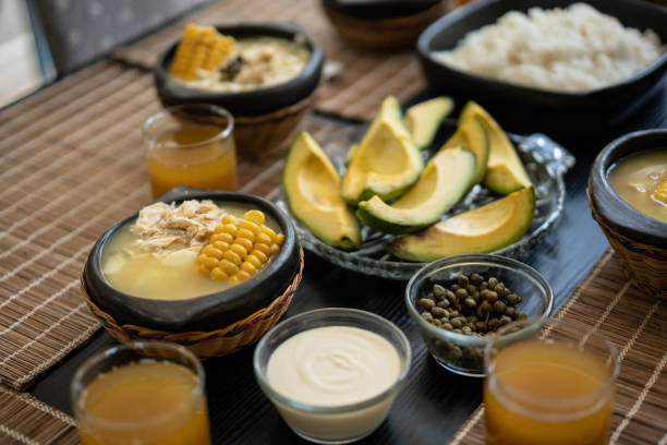 Delicious Ajiaco with avocado, capers, rice and juice set on table