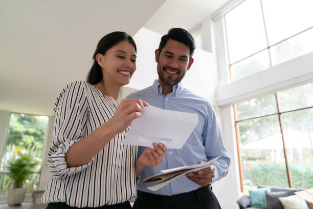 istock Latin american cheerful couple at home looking at their mail both smiling 1144436840