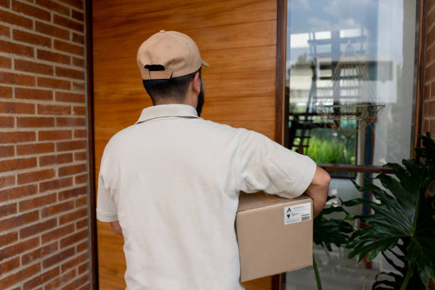 istock Male postal worker delivering a package at a customer's home 1144439678