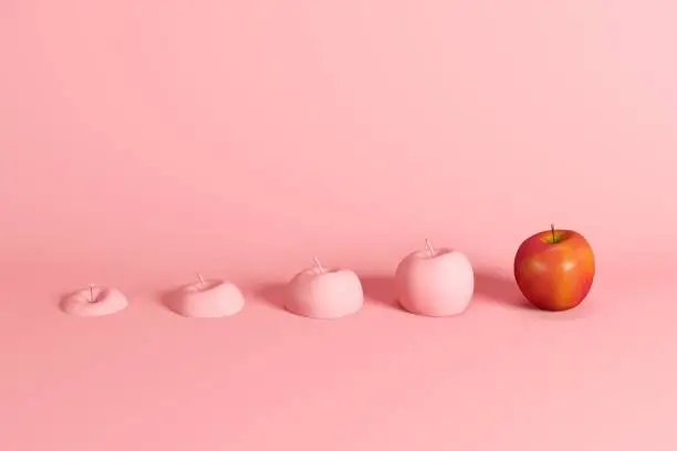 Photo of Outstanding fresh red apple and slices of apple painted in pink on pink background. Minimal fruit idea concept.