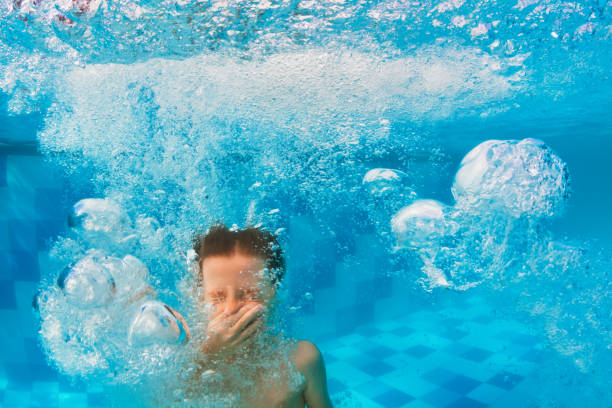 plongée de garçon dans la piscine - bubble water underwater drop photos et images de collection