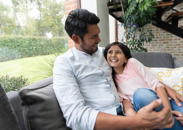 istock Joyful daddy and daughter talking and hugging on couch having fun 1144447584