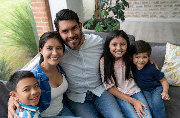 istock Beautiful latin american family hugging each other while facing at camera smiling 1144447588
