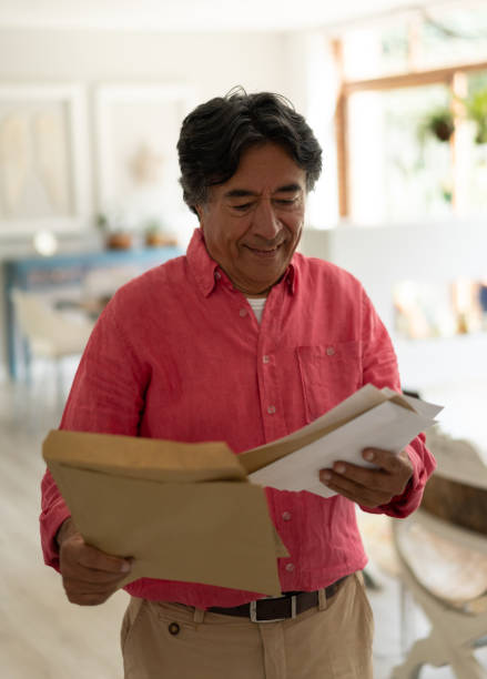 ラテンアメリカ人ハンサムな老人自宅で彼のメールをチェック - mail mailbox senior adult cheerful ストックフォトと画像