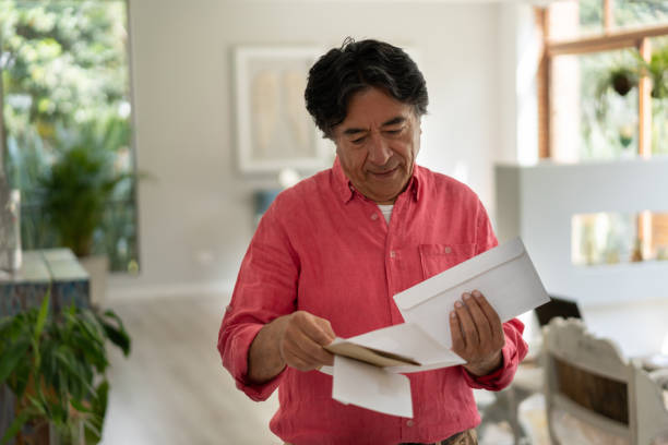 cheerful senior man at home looking at his mail - looking into mailbox imagens e fotografias de stock