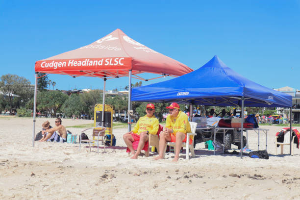オーストラリアのビーチで支援を必要とするスイマーのために海をパトロールする2人のボランティアのライフガード - gold coast australia lifeguard sea ストックフォトと画像