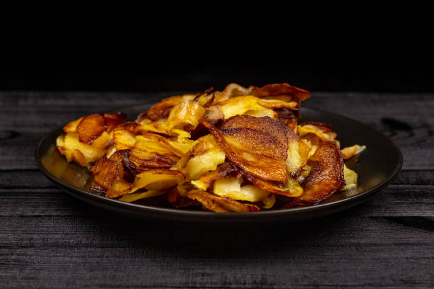 istock Fried homemade potato chips in a black plate on a wooden rustic background 1144456336