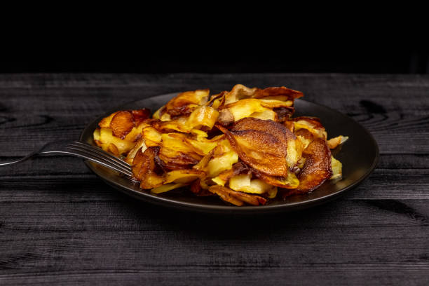 istock Fried homemade potato chips in a black plate on a wooden rustic background 1144456371
