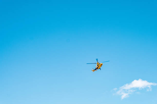 Close up of yellow, rescue helicopter against blue sky