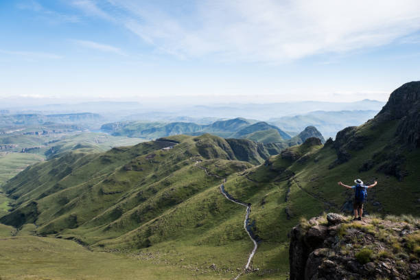 What a view! A male hikerstands on the top of the Drakensberg Mountains near Kwazulu Natal, South Africa drakensberg mountain range stock pictures, royalty-free photos & images