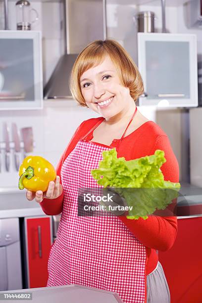 Hermosa Joven Ama De Casa De Cocina Sosteniendo Pimienta Roja Y Lechuga Foto de stock y más banco de imágenes de A cuadros