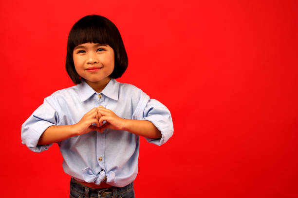 istock child  girl  Having a heart-shaped hand. 1144468414