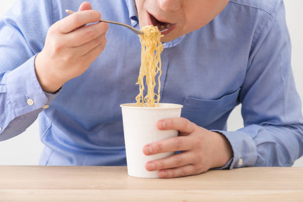 istock Man eating a cup instant noodles. 1144468585