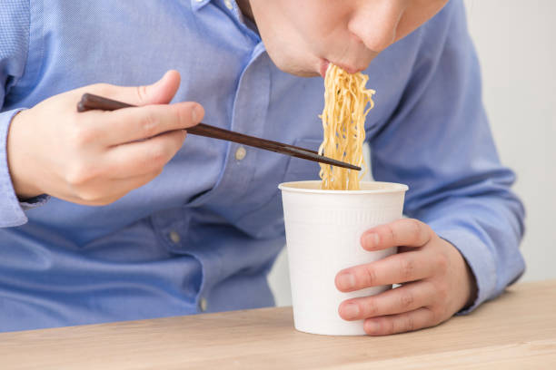 istock Man eating a cup instant noodles. 1144468631