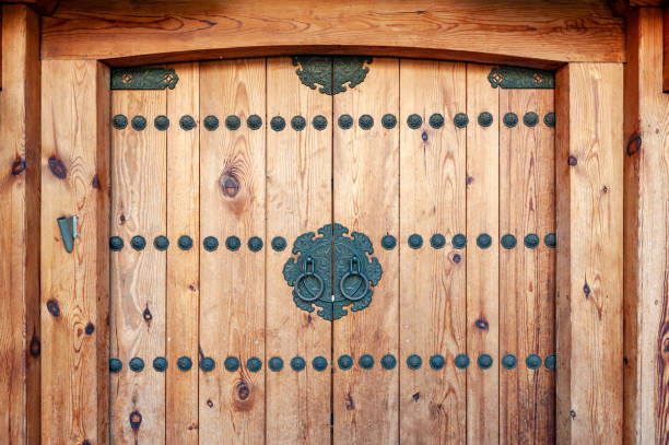корейские деревянные дверные панели, украшенные старыми черными металлическими ручками кольца в доме в древней деревне чонджу, корея - gate handle door traditional culture стоковые фото и изображения