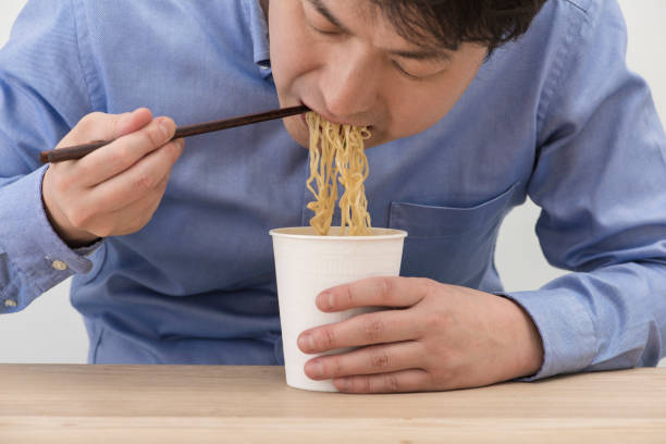 istock Man eating a cup instant noodles. 1144469400
