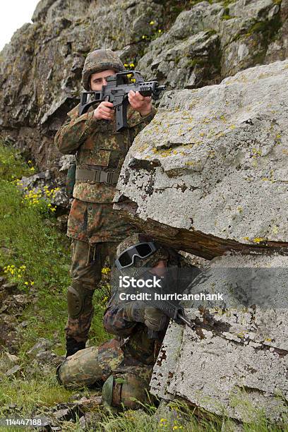 Photo libre de droit de Deux Soldats Devant Derrière Le Rock banque d'images et plus d'images libres de droit de Adulte - Adulte, Arme airsoft, Arme à feu