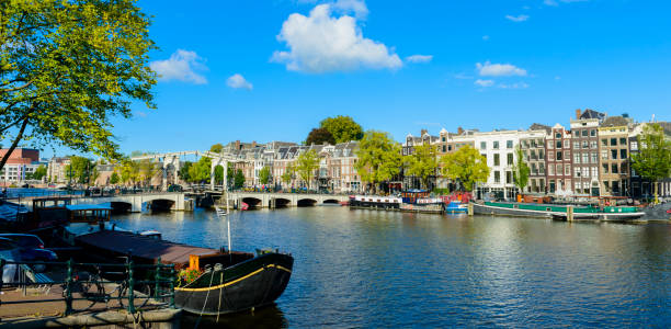 vue panoramique sur la rivière amstel et le pont skinny avec les maisons du canal à amsterdam, hollande - magere brug photos et images de collection