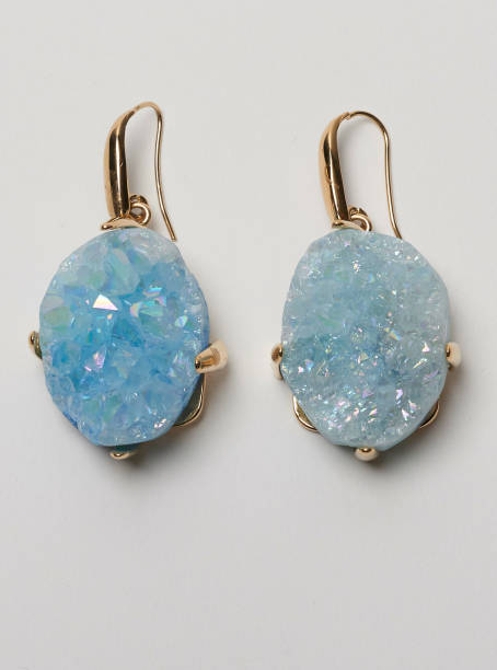 istock Golden loop earrings with beautiful blue stone studs with white background 1144480764