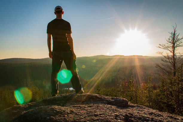 istock Young man stand on rock with forest and pond, looking to valley 1144482303
