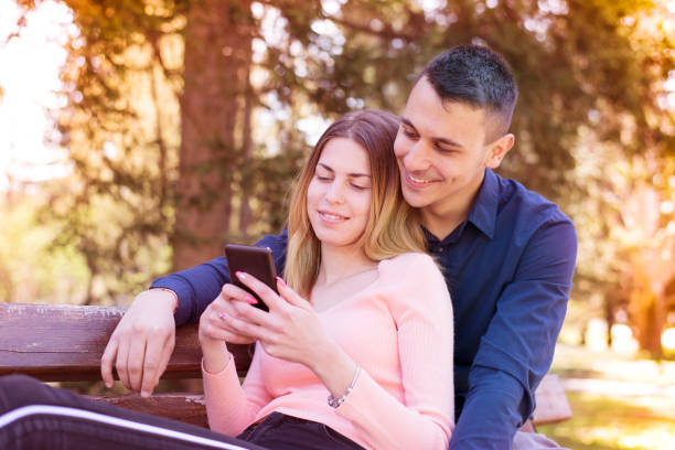 istock Young couple resting in the park and using a smartphone. 1144482381