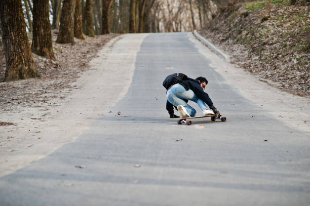 istock Street style arab man in eyeglasses with longboard 1144489833