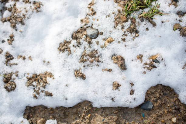 istock White snow on rocky and muddy surface 1144490027