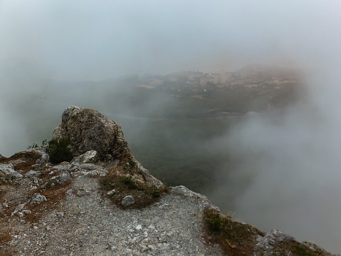 Fog on the edge of Earth. View from high mountain to South Coast of Crimea, hidden by thick fog. Selective focus on foreground. There is a place for your text