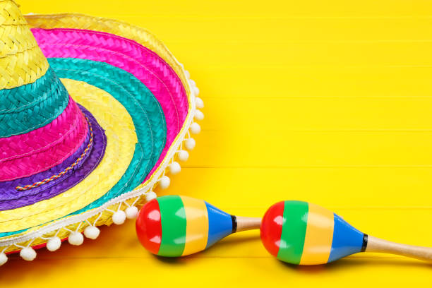 istock Mexican hat and maracas on yellow wooden table 1144492475