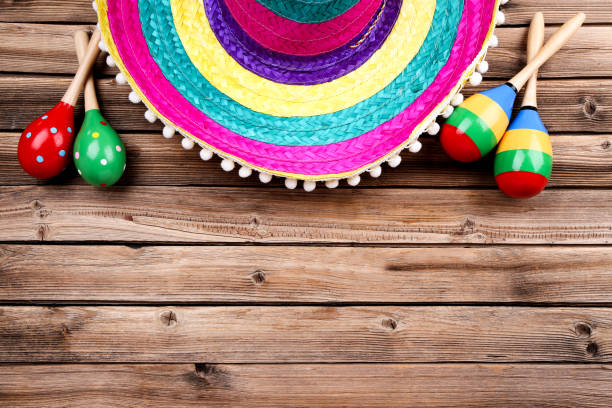istock Mexican hat and maracas on brown wooden table 1144492527