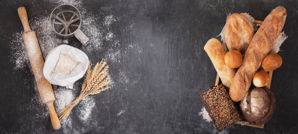 istock fresh bread with wheat ears, flour and kitchen utensils on dark board 1144492988