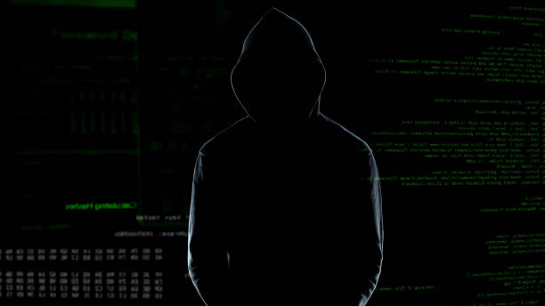 istock Male silhouette standing against numbers codes after committing cyber crime 1144493873