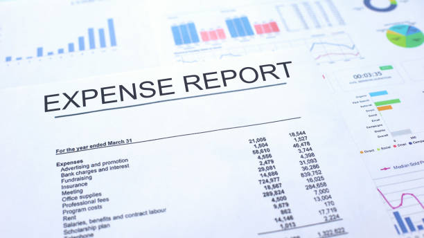 istock Expense report lying on table, graphs charts and diagrams, official document 1144494204