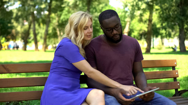 istock Multiracial couple playing game on tablet, modern painting app, free time 1144494440