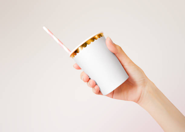 istock Hand holding Paper Cup with straws on background. Template of blank Mug for design. 1144495934