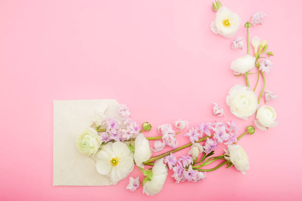 istock Floral frame made of flowers with envelope on pink background. Flat lay, top view. 1144496015