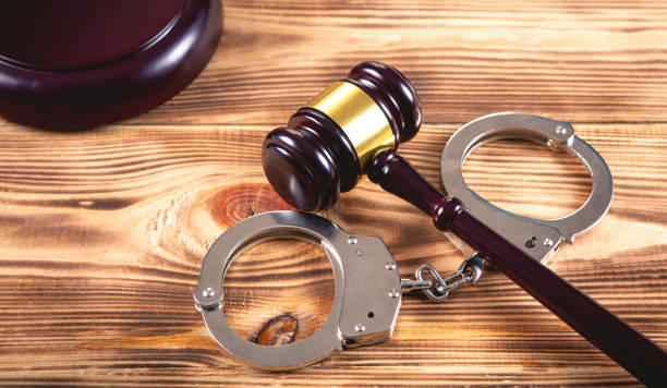 istock gavel and handcuffs on wooden background 1144496205