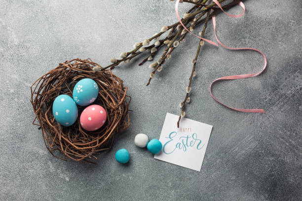istock Blue and pink colored eggs in nest and pussy willow. Easter greeting card. Top view with space for your greetings 1144497246