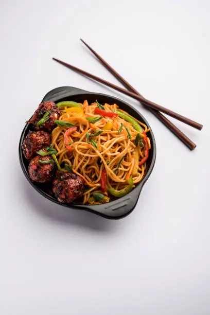 Photo of Manchurian Hakka / Schezwan noodles, popular indochinese food served in a bowl. selective focus