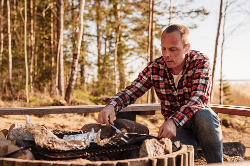 Man cooking by a campfire outdoorsy pursuit
Photo taken in sunset in nature