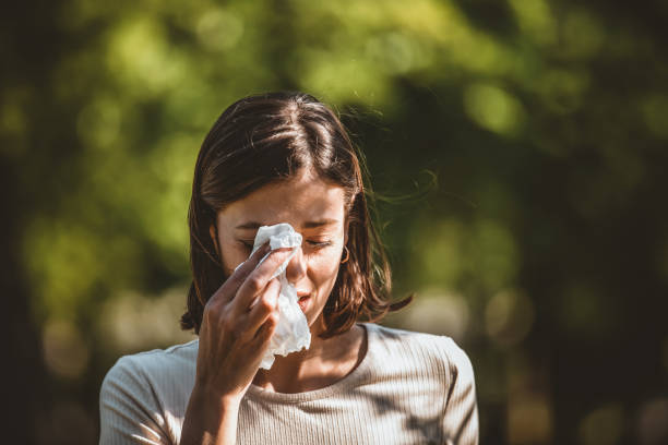 Attractive Woman Outdoors is Having Allergy Woman Blowing Her Nose With Handkerchief In Public Parkf. Sick Young Woman With Seasonal Influenza Blowing Her Nose On A Tissue. Seasonal Virus Infection. Chronic Disease Control, Allergy Induced Asthma Remedy And Chronic Pulmonary Disease Concept. allergy stock pictures, royalty-free photos & images