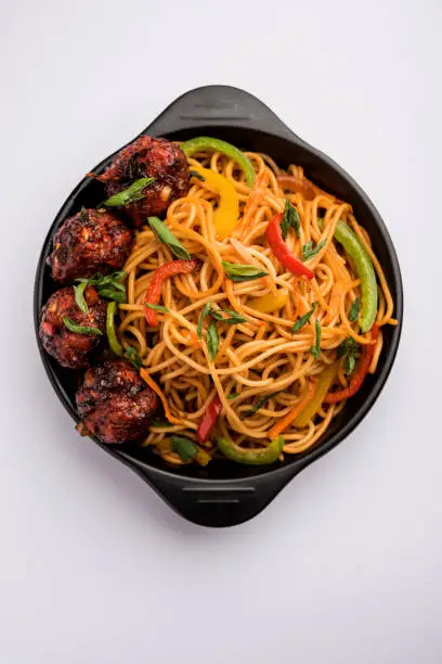 Photo of Manchurian Hakka / Schezwan noodles, popular indochinese food served in a bowl. selective focus