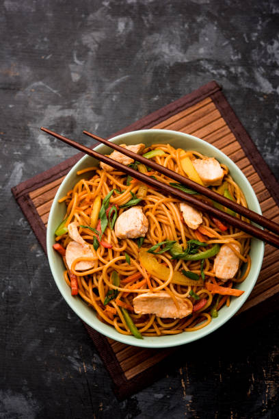istock Chicken Hakka/Schezwan noodles served in a bowl with chopsticks. selective focus 1144501934