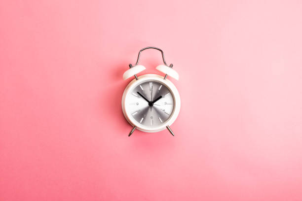 istock Retro white and silver alarm clock on a pink background 1144504205