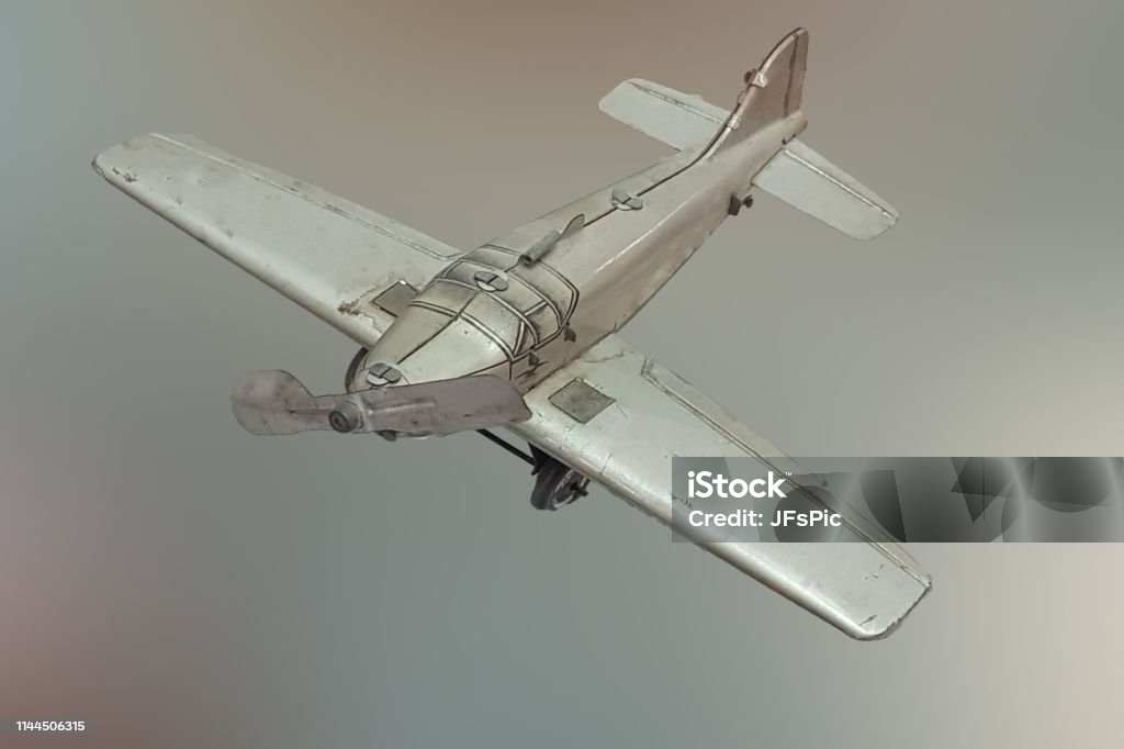 Immagine di un aereo giocattolo in metallo grigio retrò - Foto stock royalty-free di Humour
