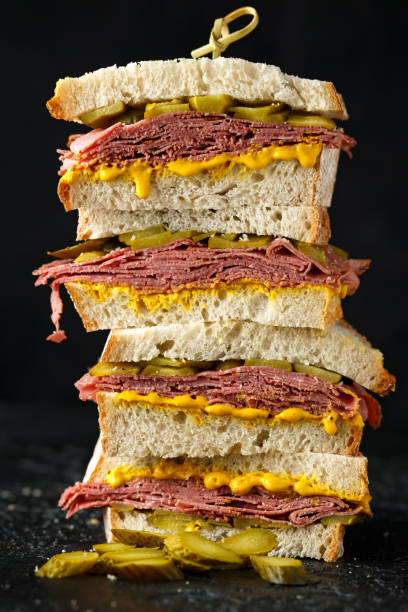 New York pastrami, gherkins and sourdough bread deli sandwich New York pastrami, gherkins and sourdough bread deli sandwich. pastrami photos stock pictures, royalty-free photos & images