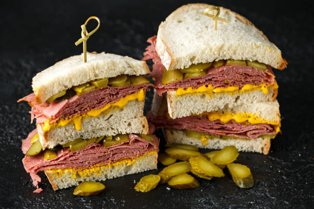 New York pastrami, gherkins and sourdough bread deli sandwich New York pastrami, gherkins and sourdough bread deli sandwich. pastrami photos stock pictures, royalty-free photos & images