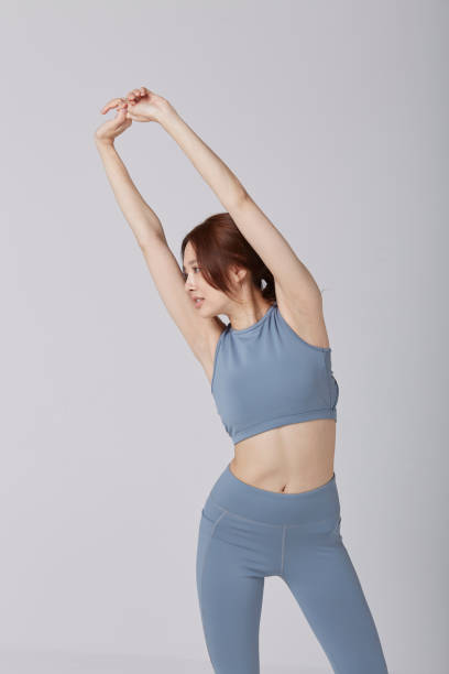 istock Asian girl wear exercise suit pose stretching in studio 1144513330