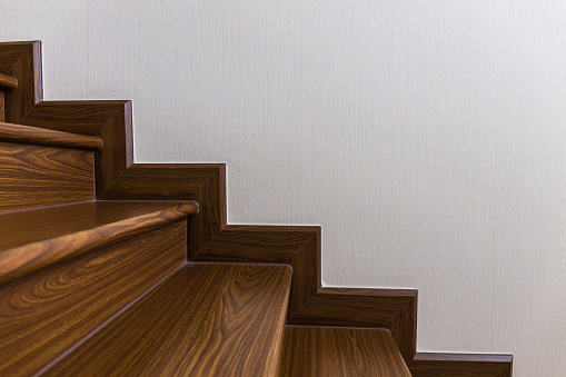 Staircase custom built home interior with wood staircase and white walls. Copy space background