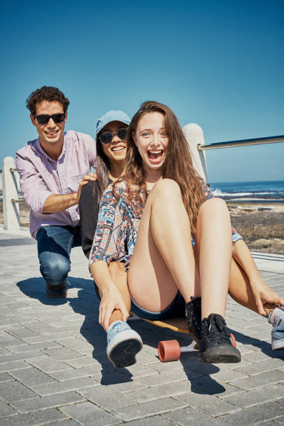 istock Three young friends on skateboard on coastal promenade 1144516339